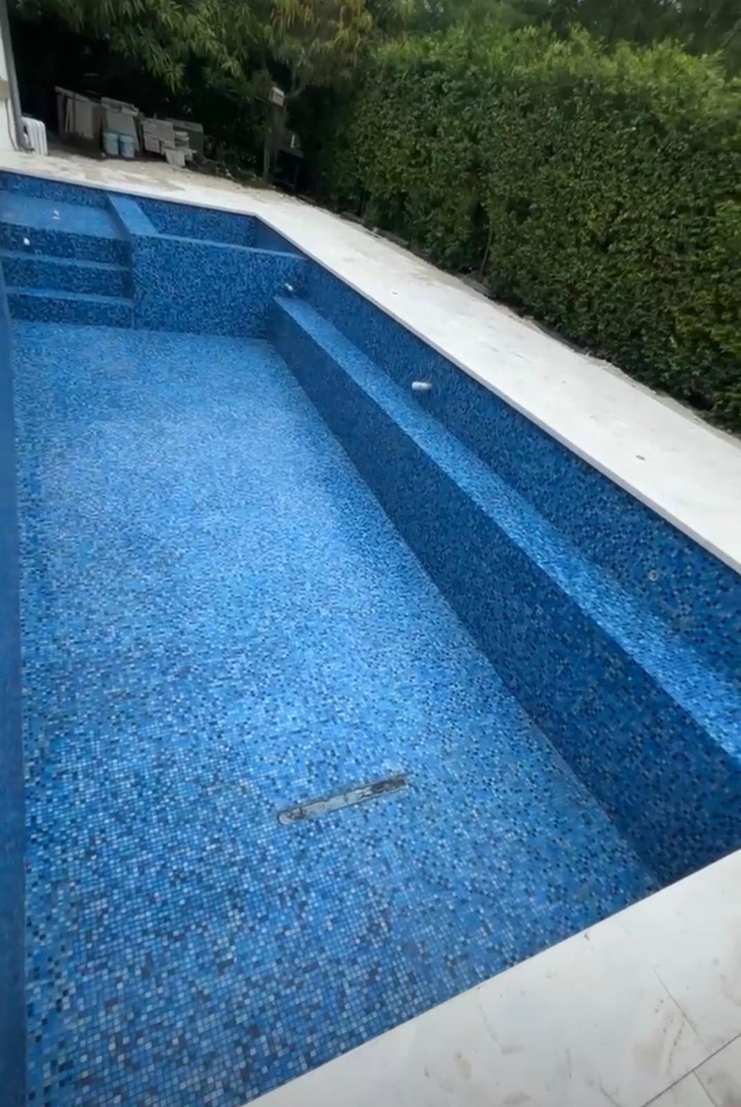 Newly tiled custom pool showcasing blue mosaic work